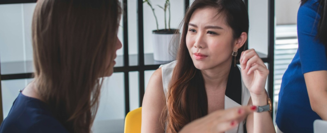 Leader giving thoughtful, honest feedback to a team member in a private workplace setting